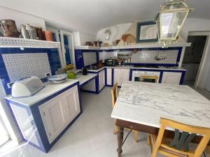 a blue and white kitchen with a table and chairs at Magi - Villa Amare in Ponza