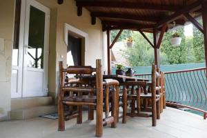 a wooden table and chairs on a porch at Hócza Apartman in Bogács