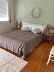1 dormitorio con 1 cama grande y suelo de madera en Casa di kikka en Bassano del Grappa