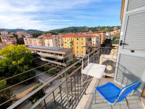 d'un balcon avec une chaise bleue et une vue sur la ville. dans l'établissement Brezza d'Estate - L'Opera Group, à La Spezia