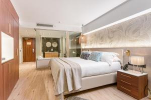 a bedroom with a large white bed and a bathroom at Sir Anthony in Playa de las Americas