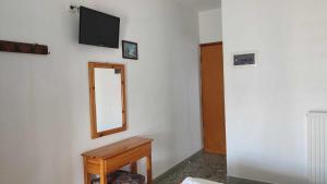Habitación con espejo, mesa y TV. en Kalogeraki Studios, en Potos