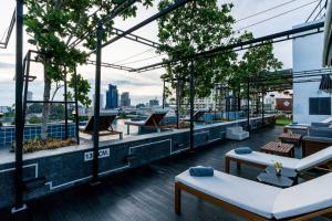 a rooftop patio with tables and chairs on a building at T Pattaya Hotel by PCL in Pattaya