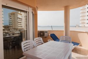 una mesa y sillas en un balcón con vistas al océano en Apartamentos Vistamar, en La Manga del Mar Menor