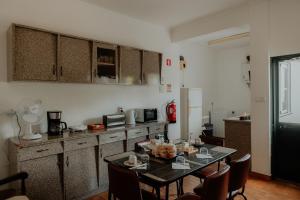 a kitchen with a table and chairs in a room at Casa Sousa Ribeiro in Praia da Vitória