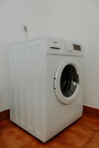 a white washing machine sitting in a room at Casa Sousa Ribeiro in Praia da Vitória