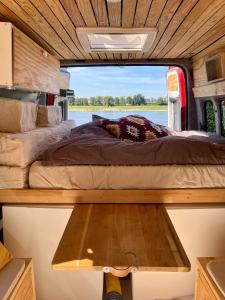 una cama en la parte trasera de una caravana con una ventana en Transi the Van, en Düsseldorf