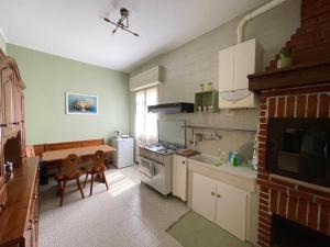una cucina con tavolo e piano cottura forno superiore di Appartamento 2, Villa Magnolia, 64mq, Lago di Garda a Peschiera del Garda