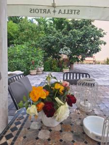 Un jarrón lleno de flores sobre una mesa. en David INN, en Băile Felix