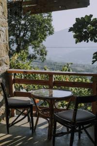 uma mesa e 2 cadeiras numa varanda com vista em The house in the village em Tirana