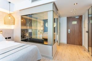 a bedroom with a bed and a large glass wall at Sir Anthony in Playa de las Americas