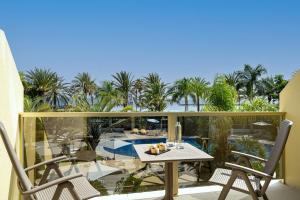 a patio with a table and chairs on a balcony at Sir Anthony in Playa de las Americas