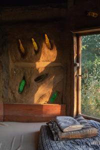 a room with a bed and a window with corn on the wall at The house in the village in Tirana