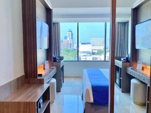 a hotel room with a bed and a large window at Arthama Tanah Abang Jakarta in Jakarta