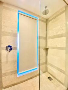 y baño con ducha y puerta de cristal azul. en Arthama Tanah Abang Jakarta, en Yakarta