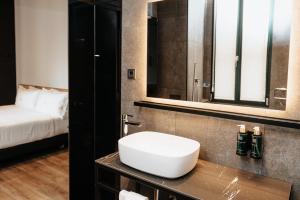 łazienka z umywalką i łóżkiem w pokoju w obiekcie Hotel Luruna Palacio Larrinaga w mieście Mundaka