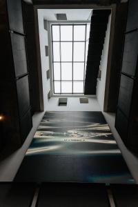 a hallway with a large window and a mosaic floor at Hotel Luruna Palacio Larrinaga in Mundaka