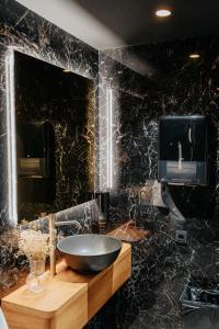 a black bathroom with a sink and a mirror at Hotel Luruna Palacio Larrinaga in Mundaka
