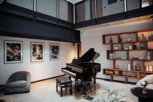 a living room with a piano and a chair at Hotel Luruna Palacio Larrinaga in Mundaka