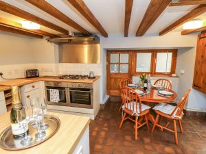 a kitchen with a table and chairs and a stove at Riverdance Cottage in Lyme Regis