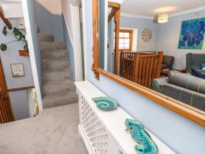 a staircase in a living room with a mirror at Riverdance Cottage in Lyme Regis