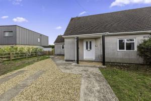 Beautiful 3 bedroom Home in Cambridgeshire في Easton on the Hill: منزل رمادي مع باب أبيض وساحة