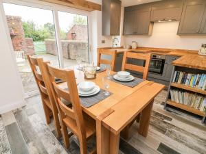 een keuken met een houten tafel en stoelen bij 2 Morton Cottages in Preston