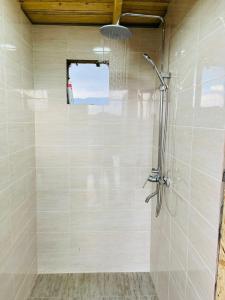 een douche met een glazen deur in de badkamer bij Bosogo Yurt camp in Bokonbayevo