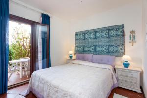 a bedroom with a bed and a balcony at Villa Briziola in San Teodoro