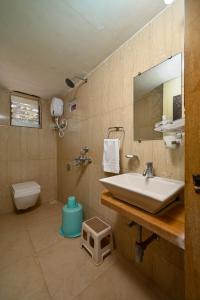 bagno con lavandino, servizi igienici e specchio di Wairkar’s Sea Pearl Resort a Malwan