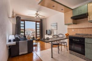 eine Küche und ein Wohnzimmer mit einem Tisch und einem Sofa in der Unterkunft Garden City Private Apartment Costa Adeje in Playa Fañabe