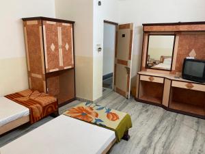 普鲁利耶Hotel Mayur的客房设有两张床、一台电视和镜子