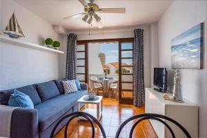 een woonkamer met een blauwe bank en een tafel bij Garden City Private Apartment Costa Adeje in Playa Fañabe