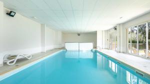 a swimming pool with blue water in a building at Les Marmottes- 38- Appart Vue montagne- 4 pers in Saint-Sorlin-dʼArves