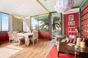 a dining room with a table and a couch at Villa Palmeras, un remanso de paz in Candelaria