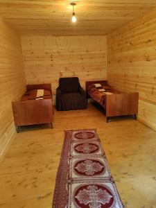 een kamer met een bed en een bank in een hut bij guest house "BETQIL" adishi in Adishi