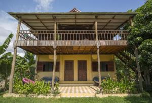 a house with a balcony on top of it at Champa Lodge in Kampot