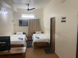 Cette petite chambre comprend 2 lits et une télévision. dans l'établissement Hotel Mayur, à Purulia