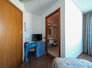 Schlafzimmer mit einem Bett und einem Schreibtisch mit einem TV in der Unterkunft L'incanto Di Boccadarno in Marina di Pisa