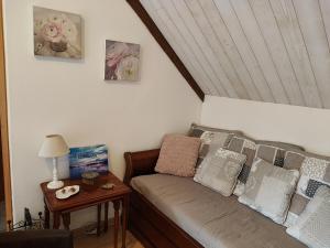 a room with a couch with pillows and a table at Les Hortensias de Kerbarch in Ploemel