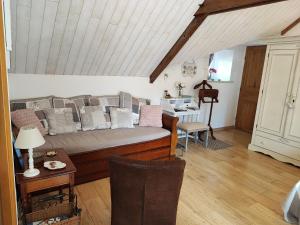 ein Wohnzimmer mit einem Sofa und einem Tisch in der Unterkunft Les Hortensias de Kerbarch in Ploemel