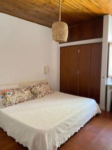 a bedroom with a white bed with a wooden ceiling at Casa Calma in Albufeira