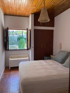 sypialnia z białym łóżkiem i oknem w obiekcie Casa Calma w Albufeirze