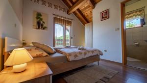 ein Schlafzimmer mit einem Bett mit einer Lampe und einem Fenster in der Unterkunft Guest house Donna in Vrata