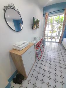 a bathroom with a sink and a mirror on the wall at ณ บ้านแม่ รีสอร์ท in Ban Rai
