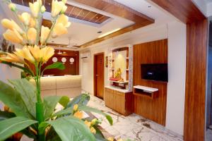 a living room with a television and a plant at HOTEL LEE GOLD in Anand