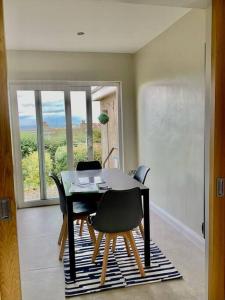 een eetkamer met een tafel en stoelen en een raam bij Red Skies Seaview Portstewart Beach Golfcourse Seafront View in Portstewart