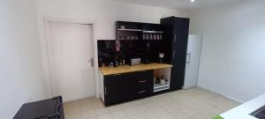 a black kitchen with a counter in a room at Les chambres du Manguier in Mamoudzou