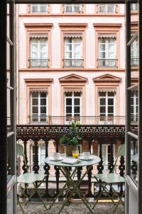 リヨンにあるホテル デュ ドファンのピンクの建物前のテーブル