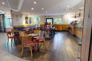 une salle à manger avec des tables et des chaises dans un restaurant dans l'établissement Village Hotel Cardiff, à Cardiff